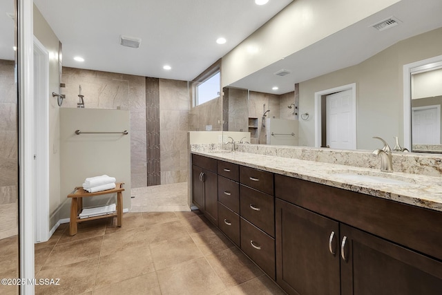 bathroom with vanity and a tile shower