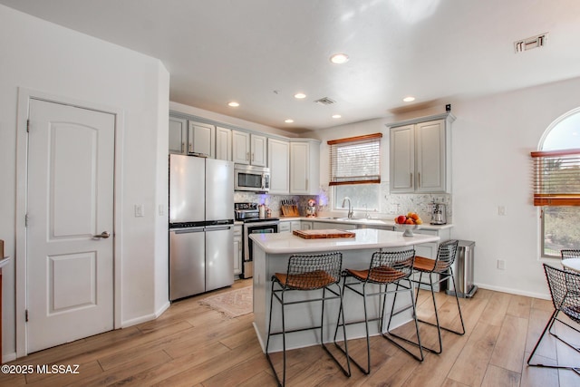 kitchen featuring sink, gray cabinets, stainless steel appliances, and light hardwood / wood-style flooring