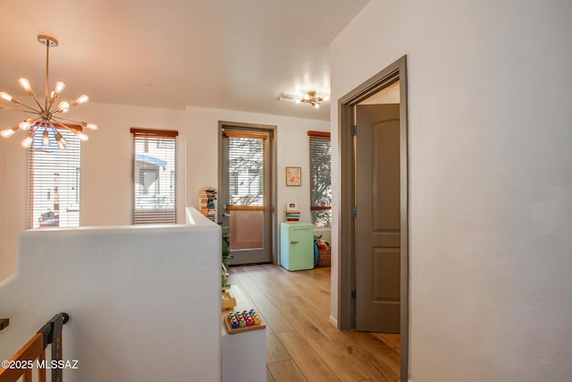 corridor featuring a chandelier and light hardwood / wood-style floors