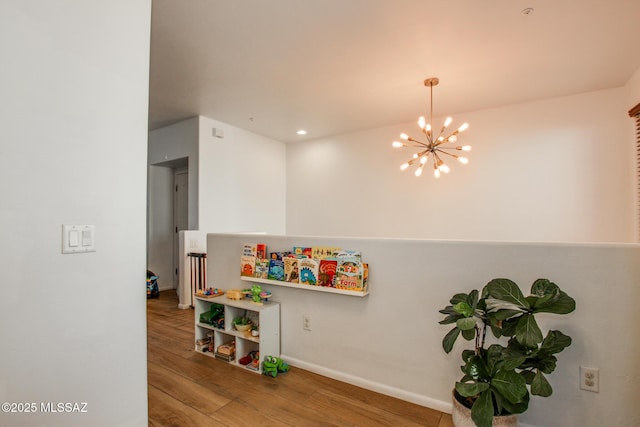 rec room featuring wood-type flooring and a chandelier