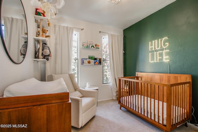 carpeted bedroom featuring a crib