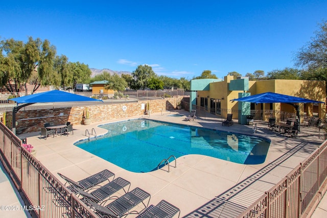 view of swimming pool with a mountain view and a patio