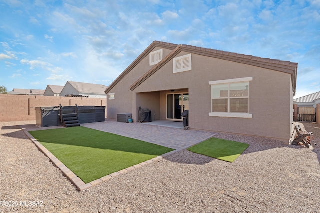 rear view of property featuring a yard, a fenced backyard, a patio, and stucco siding