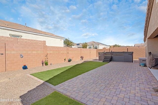 view of patio featuring a fenced backyard and a hot tub