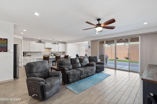 living area with a ceiling fan, light wood-style flooring, and recessed lighting