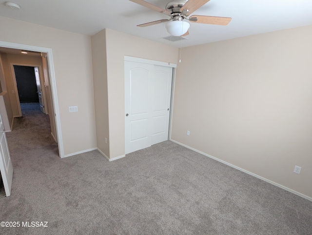 unfurnished bedroom featuring ceiling fan, a closet, and light carpet