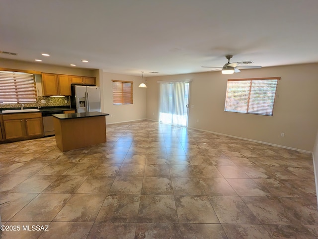 kitchen featuring tasteful backsplash, a wealth of natural light, hanging light fixtures, and stainless steel appliances