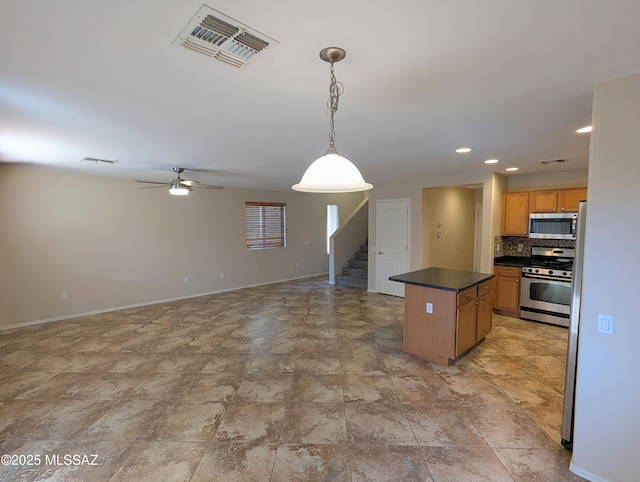 kitchen with a kitchen island, decorative light fixtures, stainless steel appliances, backsplash, and ceiling fan