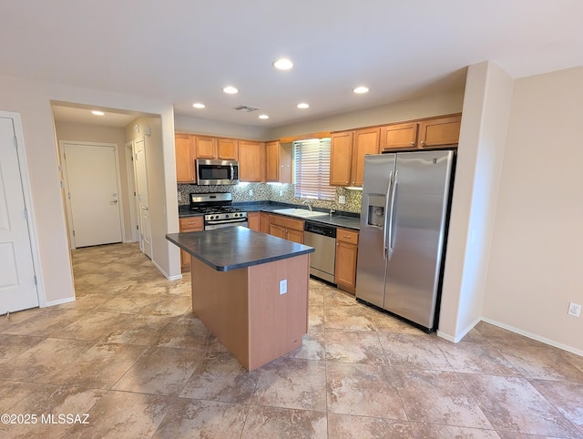 kitchen with tasteful backsplash, appliances with stainless steel finishes, sink, and a kitchen island