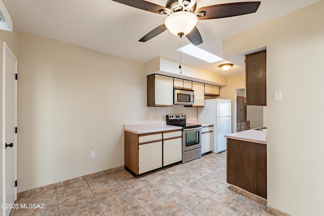 kitchen featuring appliances with stainless steel finishes, ceiling fan, and a skylight