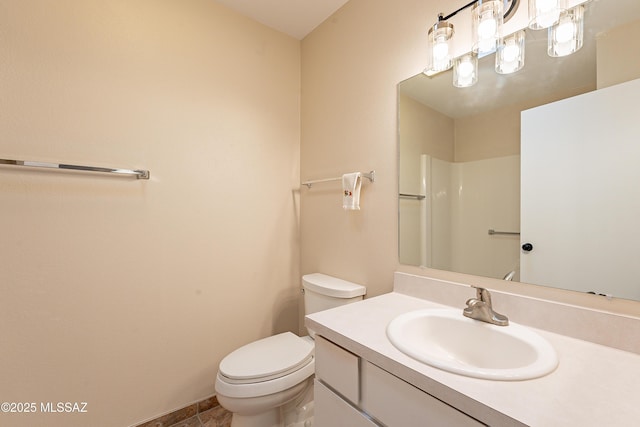 bathroom with vanity, a shower, and toilet