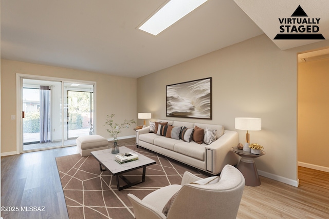 living room with hardwood / wood-style flooring and a skylight