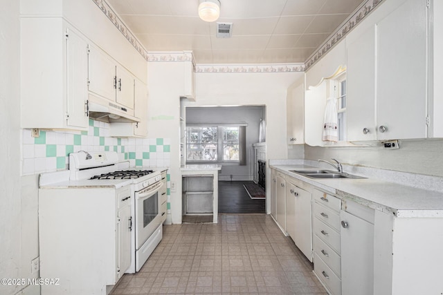 kitchen with gas range gas stove, backsplash, white cabinets, and sink