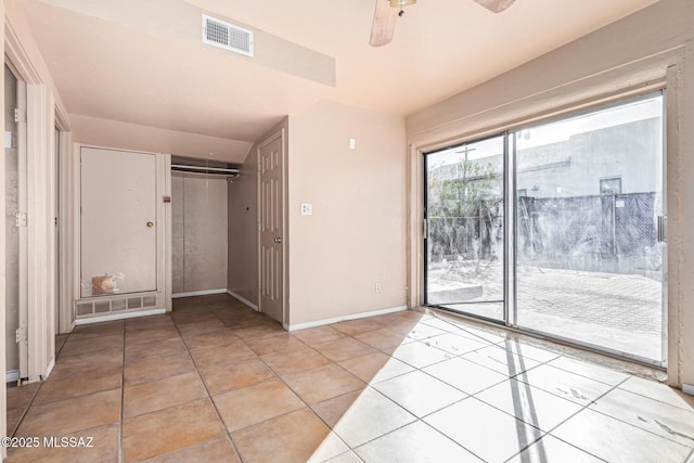 unfurnished bedroom featuring ceiling fan, access to outside, light tile patterned flooring, and a closet