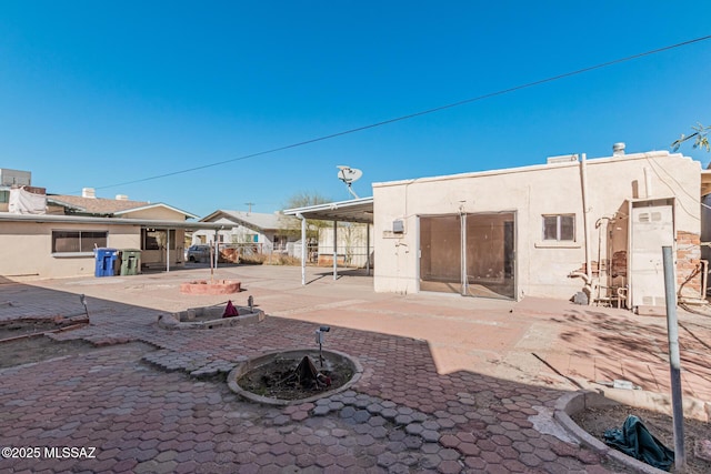 back of house with a patio area and a fire pit