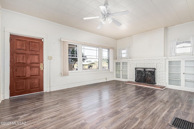 unfurnished living room featuring ceiling fan, dark hardwood / wood-style flooring, and a fireplace