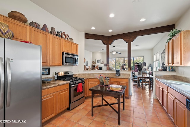 kitchen featuring ceiling fan, beam ceiling, stainless steel appliances, and light tile patterned flooring