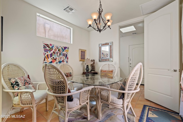 dining space with light tile patterned floors and a chandelier