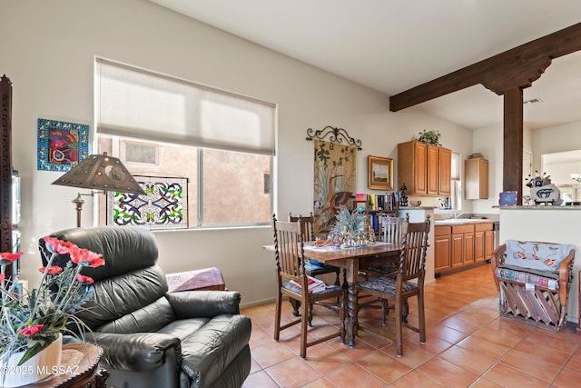 dining room featuring light tile patterned flooring and beamed ceiling