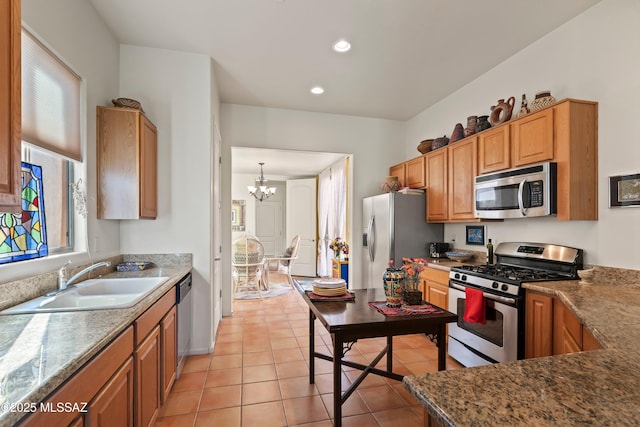 kitchen with light tile patterned floors, appliances with stainless steel finishes, sink, and a notable chandelier