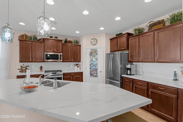 kitchen featuring tasteful backsplash, appliances with stainless steel finishes, sink, and light stone counters