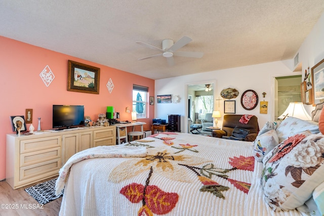 bedroom featuring a textured ceiling, ceiling fan, and hardwood / wood-style flooring