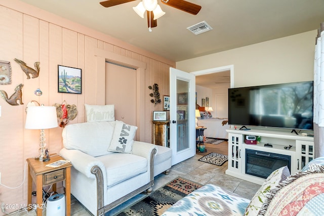 living room featuring wooden walls and ceiling fan