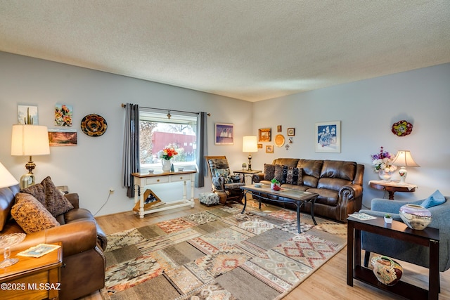 living room with light hardwood / wood-style flooring and a textured ceiling