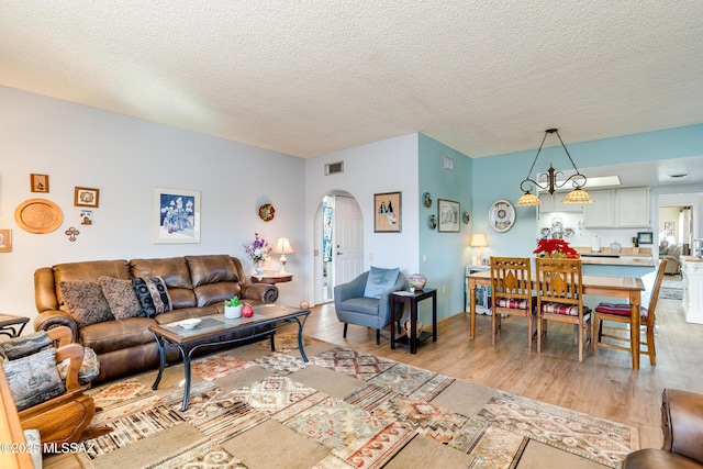 living room with light hardwood / wood-style floors and a textured ceiling