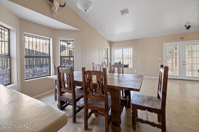 dining space featuring french doors and vaulted ceiling