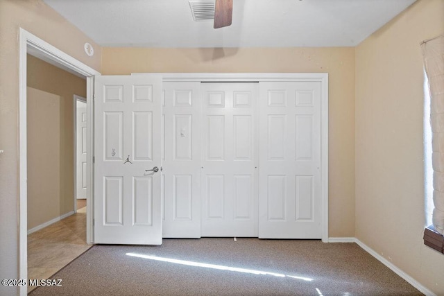 unfurnished bedroom with a closet, carpet floors, and ceiling fan