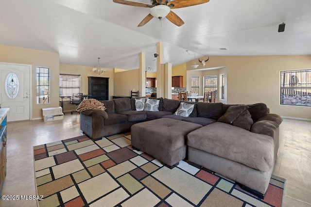 living room featuring ceiling fan with notable chandelier and vaulted ceiling