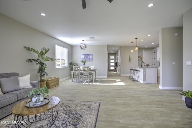 living room with sink and light wood-type flooring