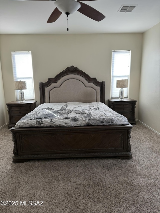 carpeted bedroom with ceiling fan and multiple windows