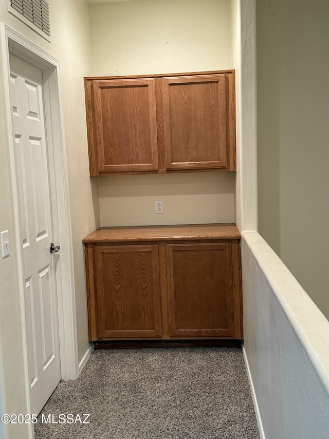 hallway with dark colored carpet