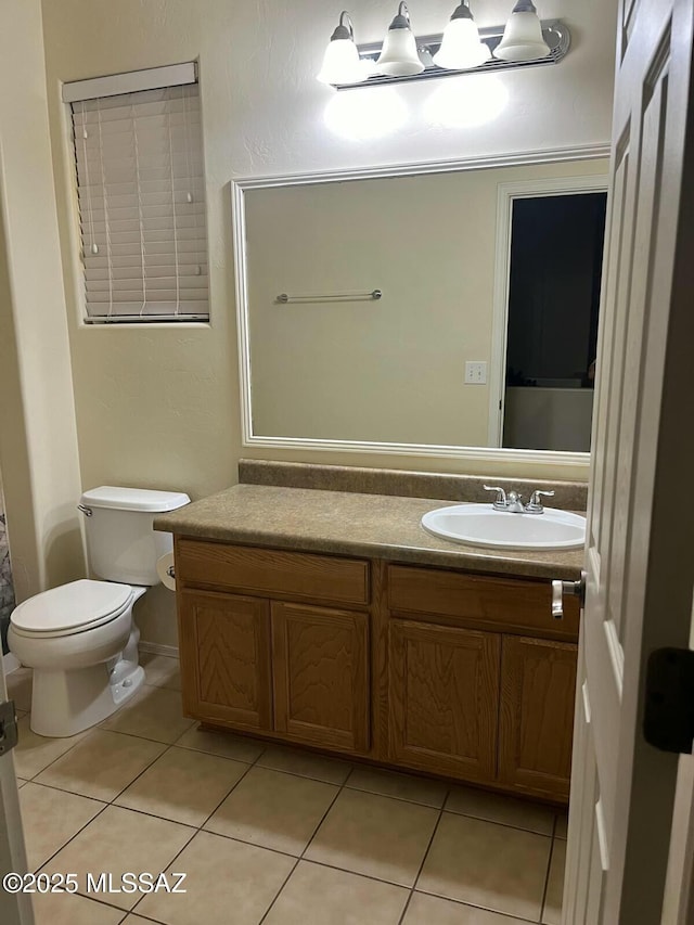 bathroom featuring toilet, vanity, and tile patterned flooring