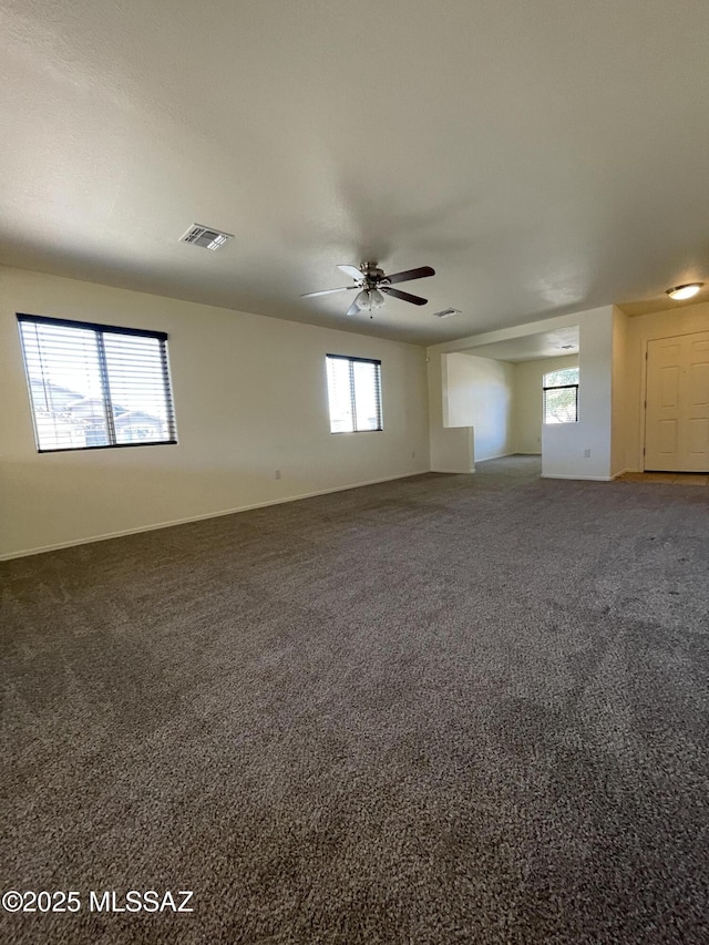 carpeted empty room featuring ceiling fan and a healthy amount of sunlight