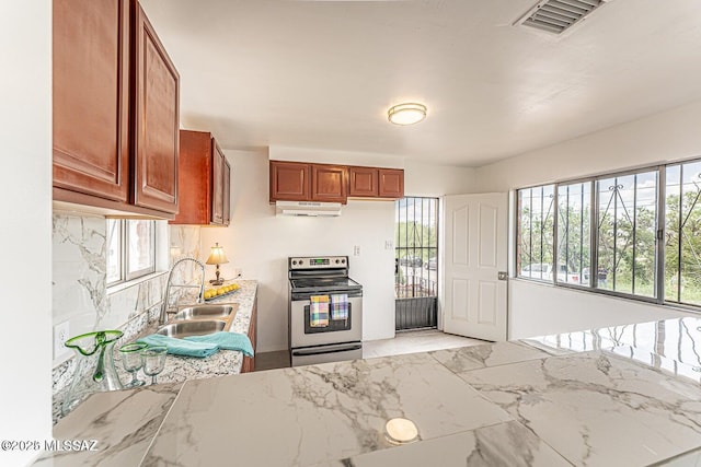 kitchen featuring light stone countertops, sink, and stainless steel electric stove