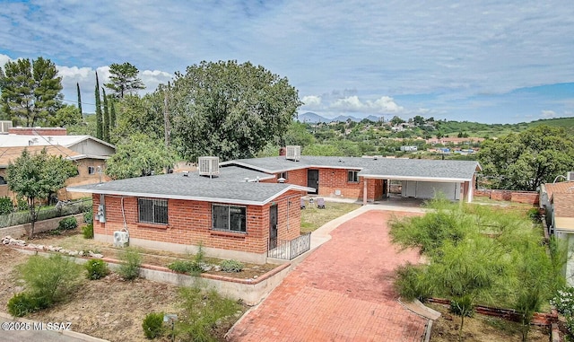 view of front of home featuring central AC unit and a carport