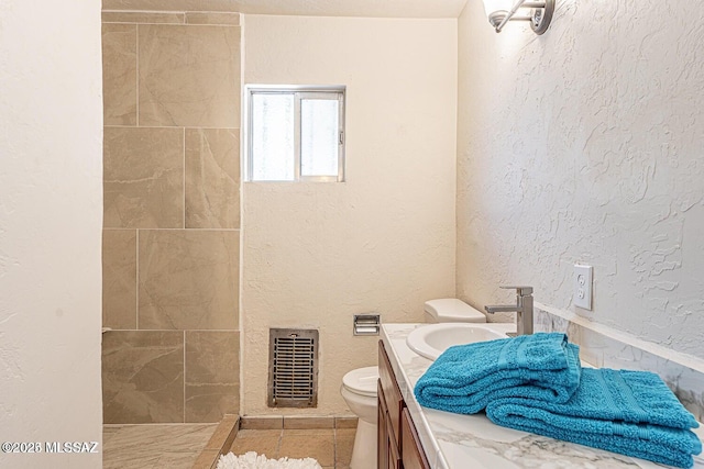 bathroom with toilet, vanity, and tile patterned floors