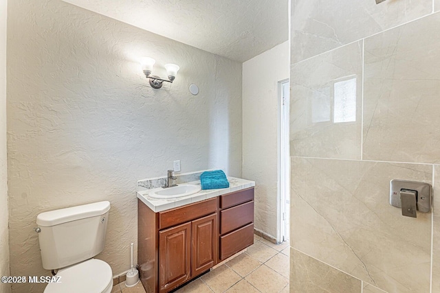 bathroom featuring tile patterned floors, toilet, vanity, and a textured ceiling