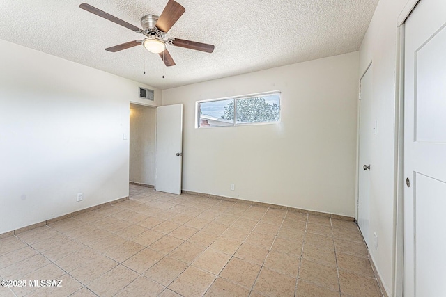 unfurnished bedroom featuring ceiling fan, light tile patterned flooring, and a textured ceiling