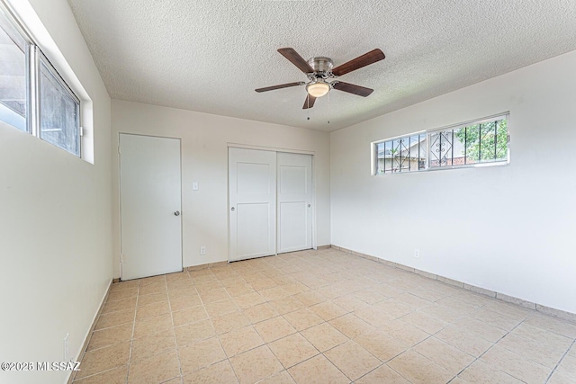 unfurnished bedroom featuring a textured ceiling and ceiling fan