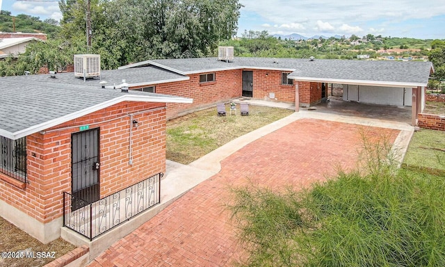 view of front of home with central AC and a carport