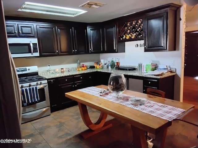 kitchen featuring light stone countertops and stainless steel appliances