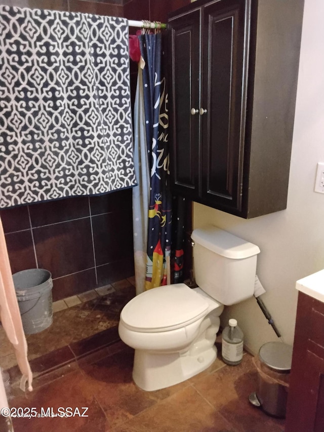 bathroom with curtained shower, toilet, vanity, and tile patterned flooring