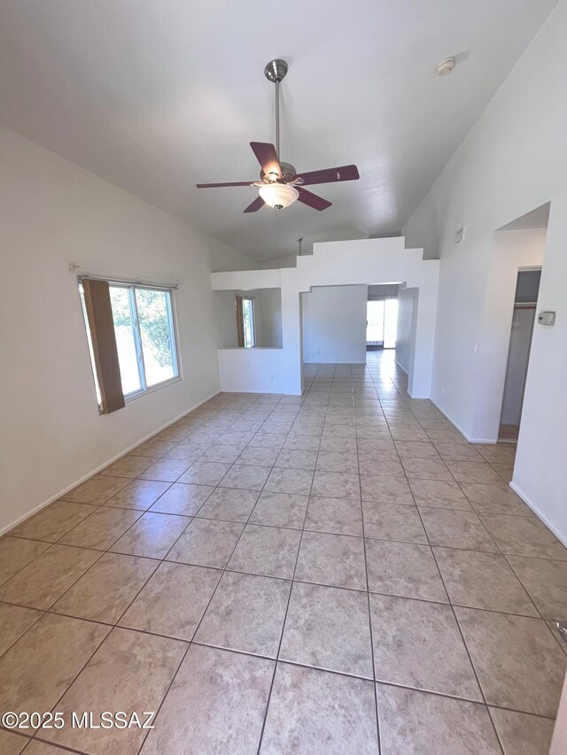 tiled living room featuring ceiling fan and high vaulted ceiling