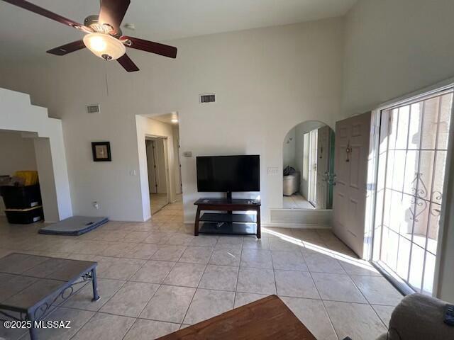 tiled living room with high vaulted ceiling and ceiling fan