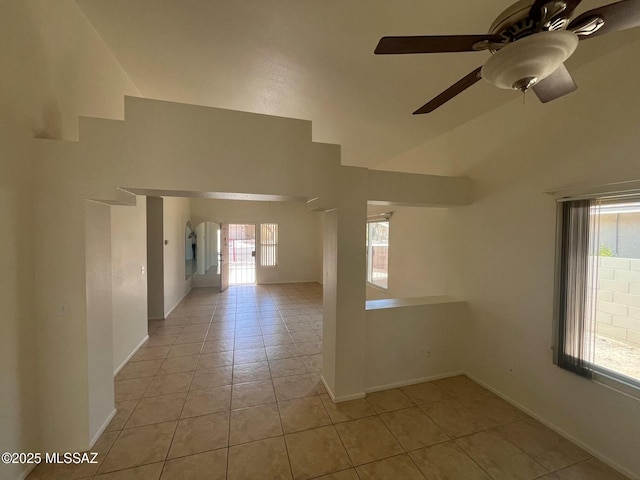 unfurnished room featuring light tile patterned floors, baseboards, a ceiling fan, and vaulted ceiling