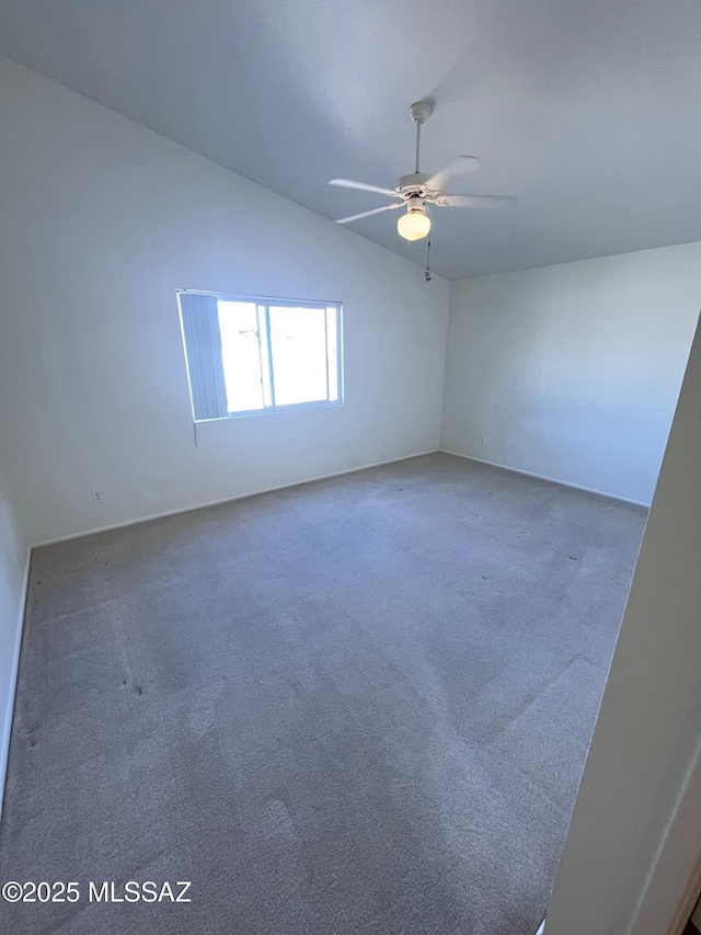 carpeted empty room featuring vaulted ceiling and a ceiling fan